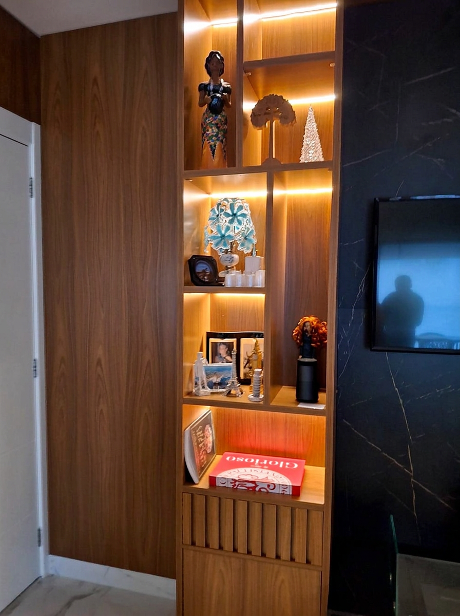 Estante planejada em madeira com iluminação de LED ao lado do painel de TV